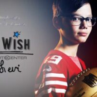 Levi holding a football and wearing a 49rs jersey