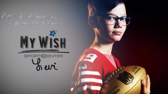 Levi holding a football and wearing a 49rs jersey